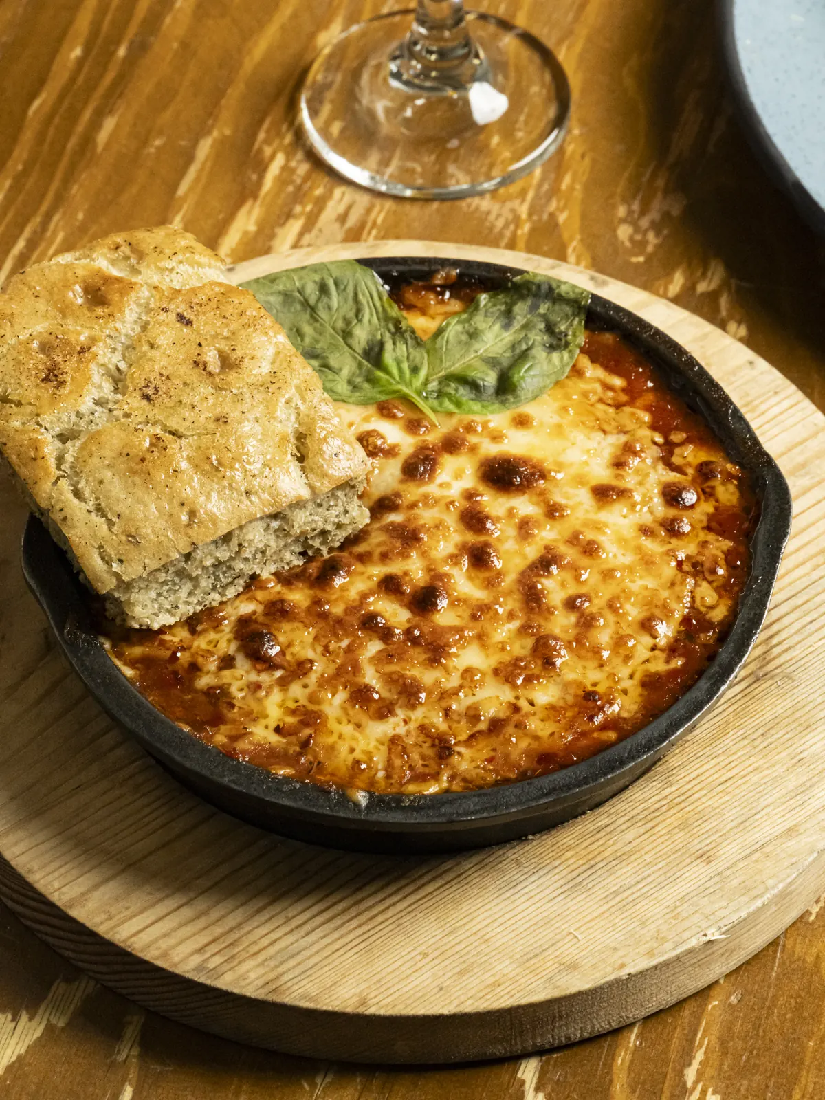 Cazuela gratinada recién salida del horno, servida con pan focaccia